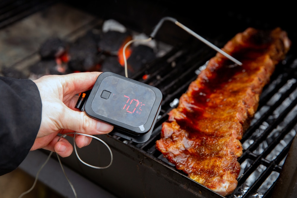 man using meat thermometer