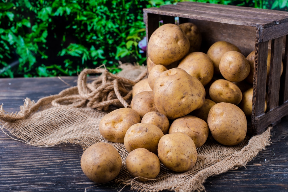 wooden box sacking and potatoes on table